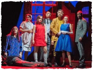 Cast stand on stage in different coloured outfits to match their character's name. A red light is overhead and someone is dead on the floor