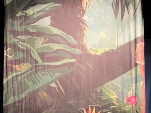 A printed cloth of a jungle scene with exotic flowers.