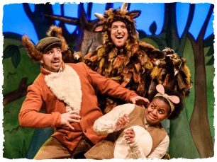 three performers dressed as animals posing for a group photo