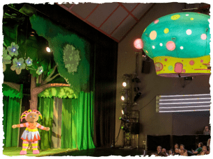 Igglepiggle's ship flies over the audience towards upsy daisy who stands waiting on stage