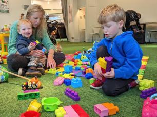 A group of children play with their parent