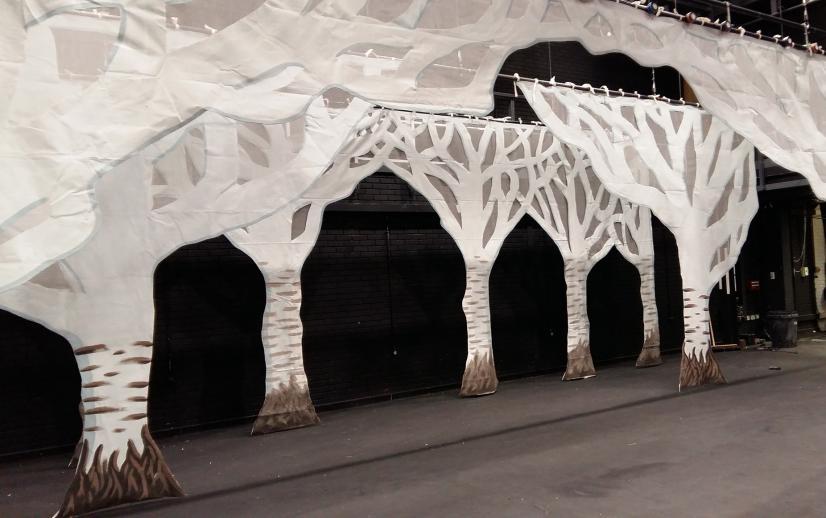 A stage with white trees made out of cloth