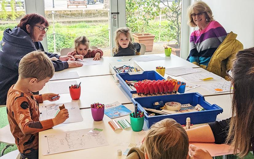 A group of people sit around a table doing an activity