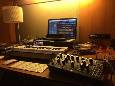A laptop and sound mixer on a table in a dimly lit room