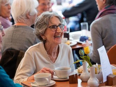 A woman sits in the cafe enjoying a coffee. 